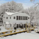 Beautiful white house surrounded by trees on a snowy winter day
