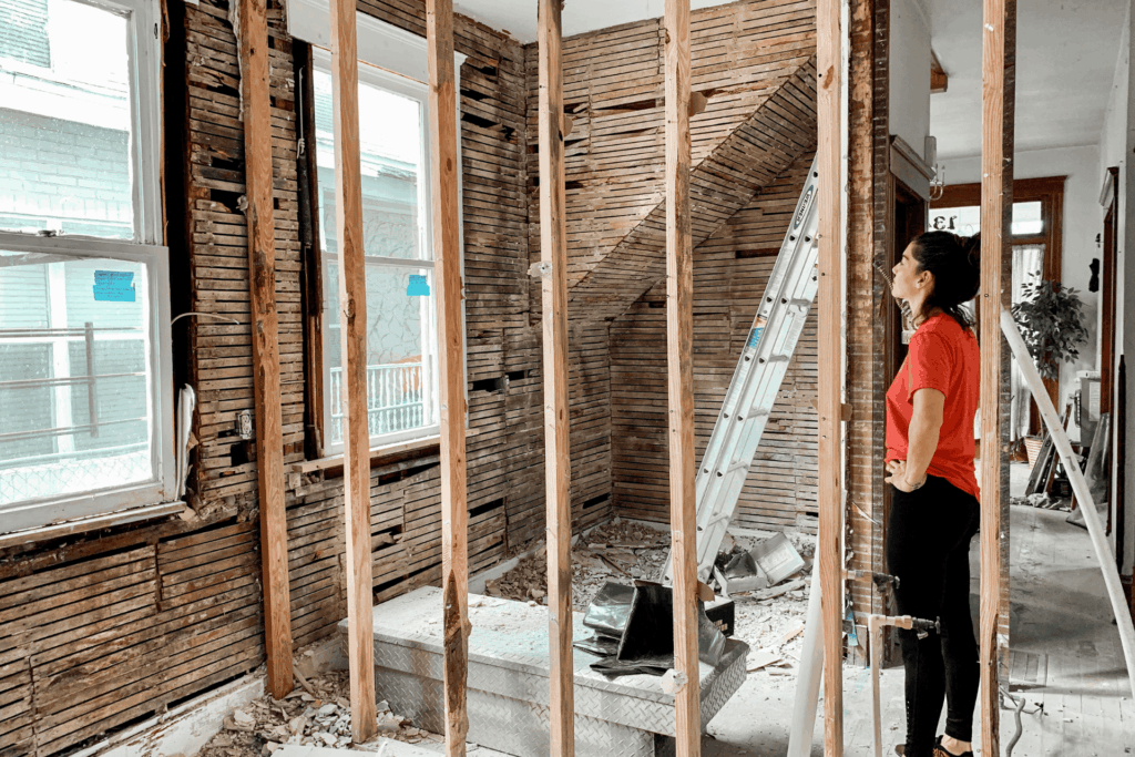 Investor reviewing a property under renovation with exposed framing.