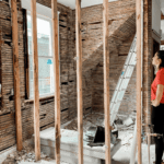 Investor reviewing a property under renovation with exposed framing.
