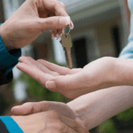 Real estate agent giving keys to buyer during home closing.
