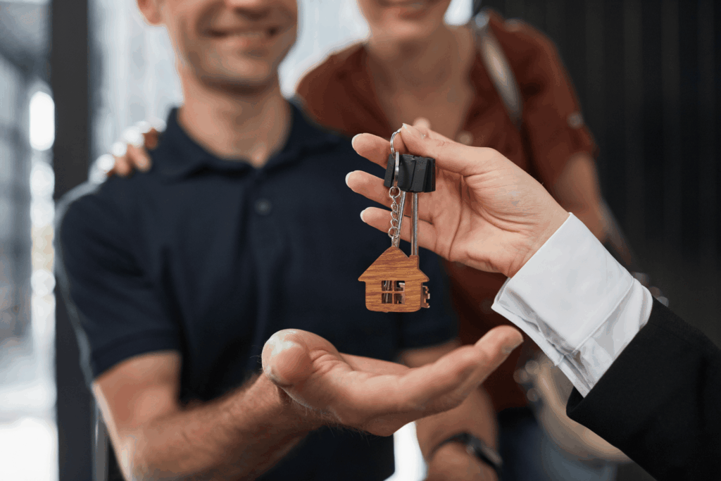 Real estate agent handing house keys to new homeowners.