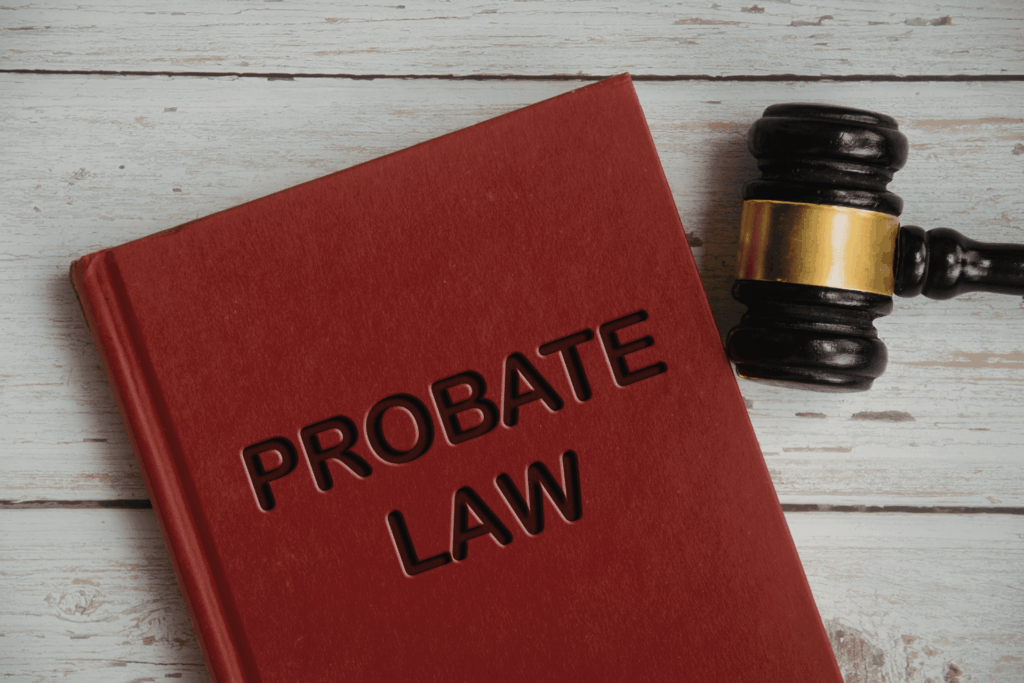 Red book labeled “Probate Law” beside a judge’s gavel on a wooden surface.