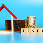 Wooden house frame, cash, and blocks spelling “ASSET,” symbolizing assets divided.