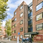 Brick multifamily apartment building in an urban neighborhood.