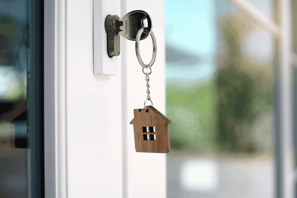 House-shaped keychain hanging from a key in a door lock