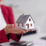 Person holding a small model house in their hands