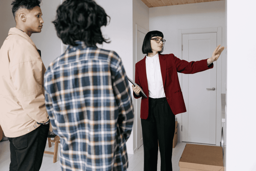 Real estate agent showing a home interior to two clients