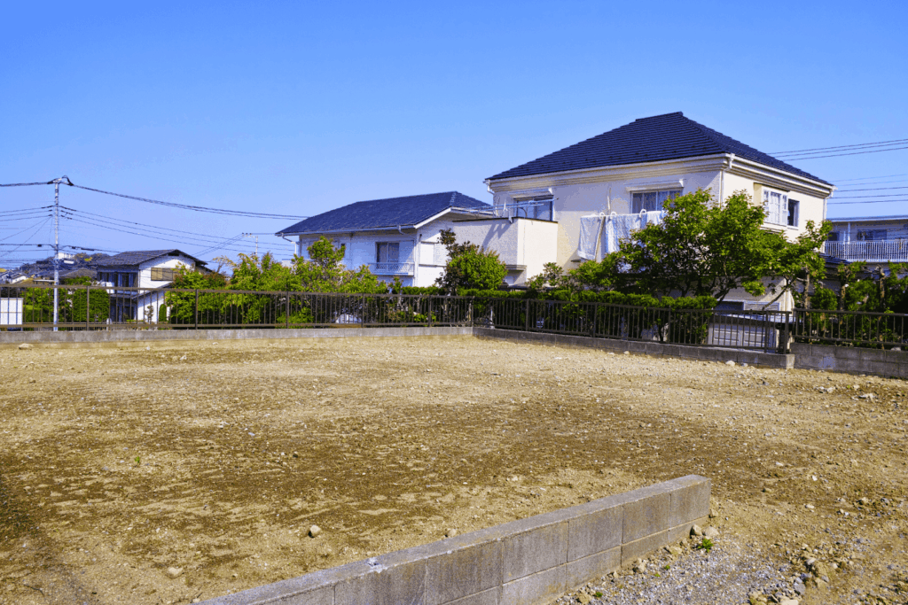 Vacant plot of land in a residential neighborhood on a sunny day