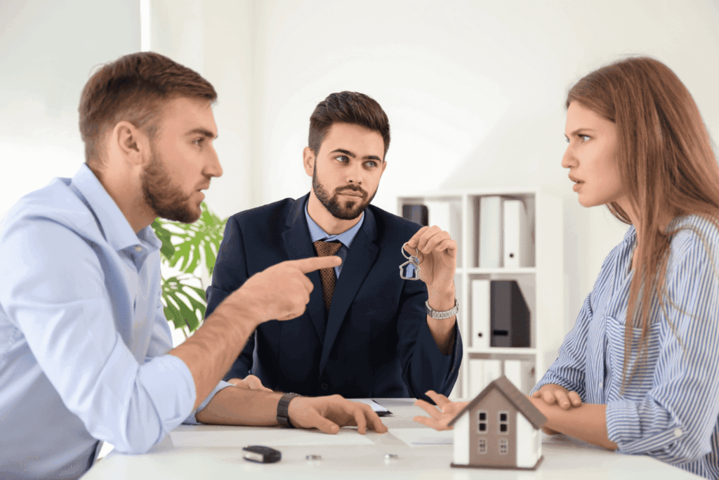 Couple arguing with a real estate agent holding house keys
