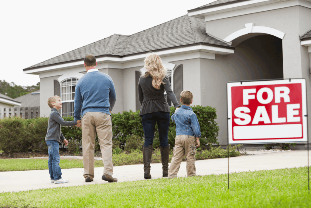 Family viewing a house for sale in a suburban neighborhood.