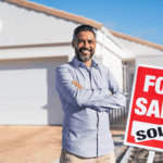 Man celebrating successful home sale beside sold real estate sign.