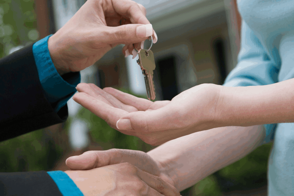 Real estate agent giving keys to buyer during home closing.