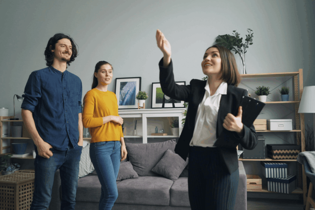Real estate agent showing a home to a young couple.