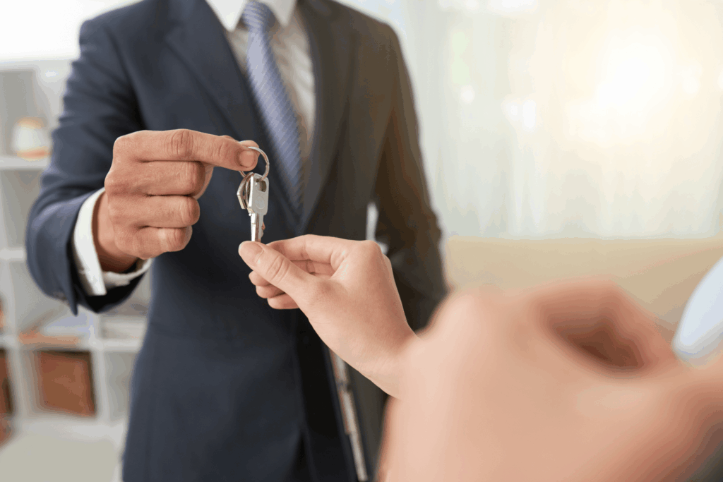 Real estate agent handing house keys to a person