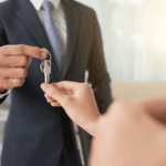 Real estate agent handing house keys to a person