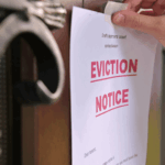 Eviction notice being taped to the front door of a house by a landlord or official.