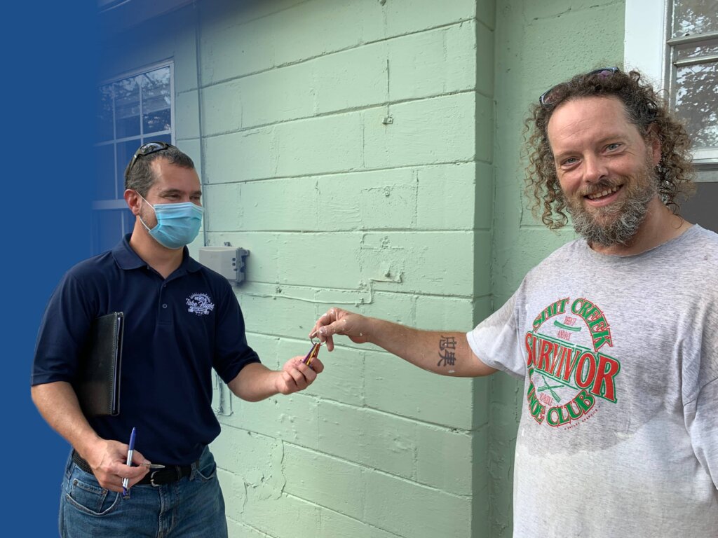A happy homeowner handing keys over to Mike.