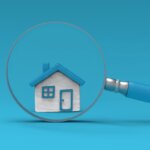 Model house under magnifying glass with blue background