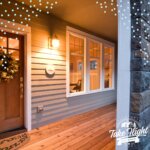Illuminated front porch with a wreath on door at dusk