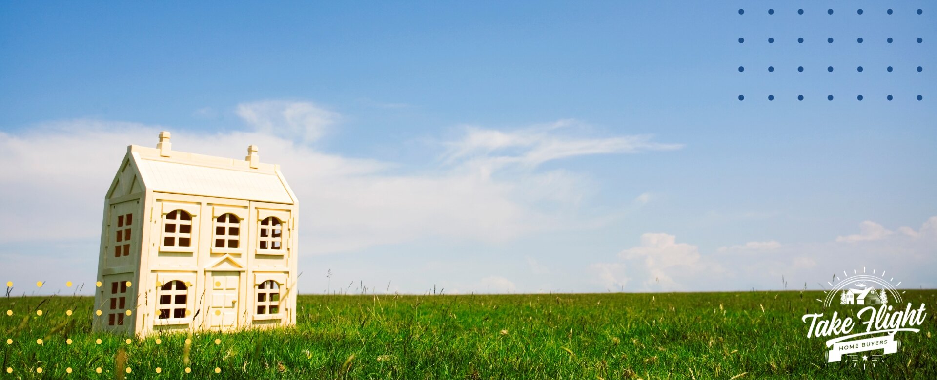 Tiny white model house on grass with open sky above