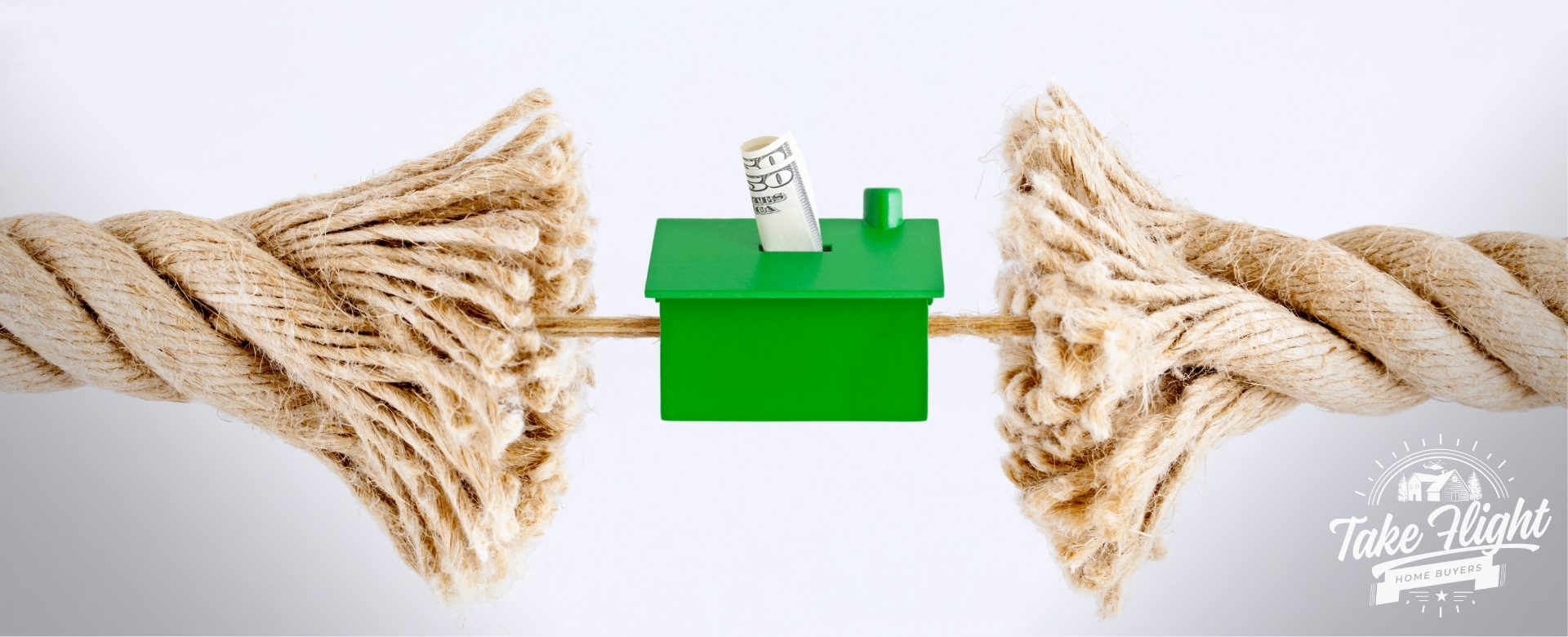Rope splitting with a green plastic house in the middle with a $50 bill in it.