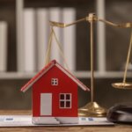 model red house sitting on a desk with a gavel and scale