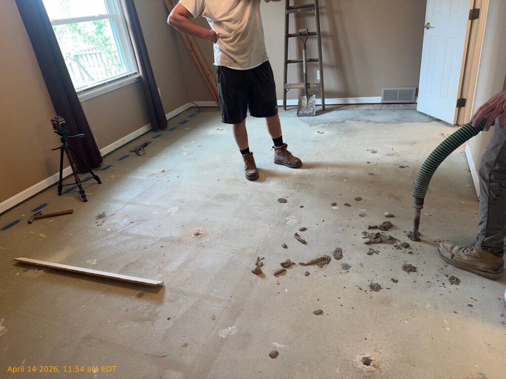 Contractors investigating hidden voids beneath settled concrete slab in Medina Ohio