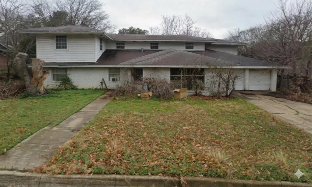Vacant house with overgrown yard needing repairs