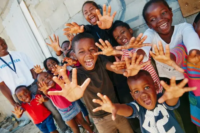 Group of smiling children reaching toward the camera
