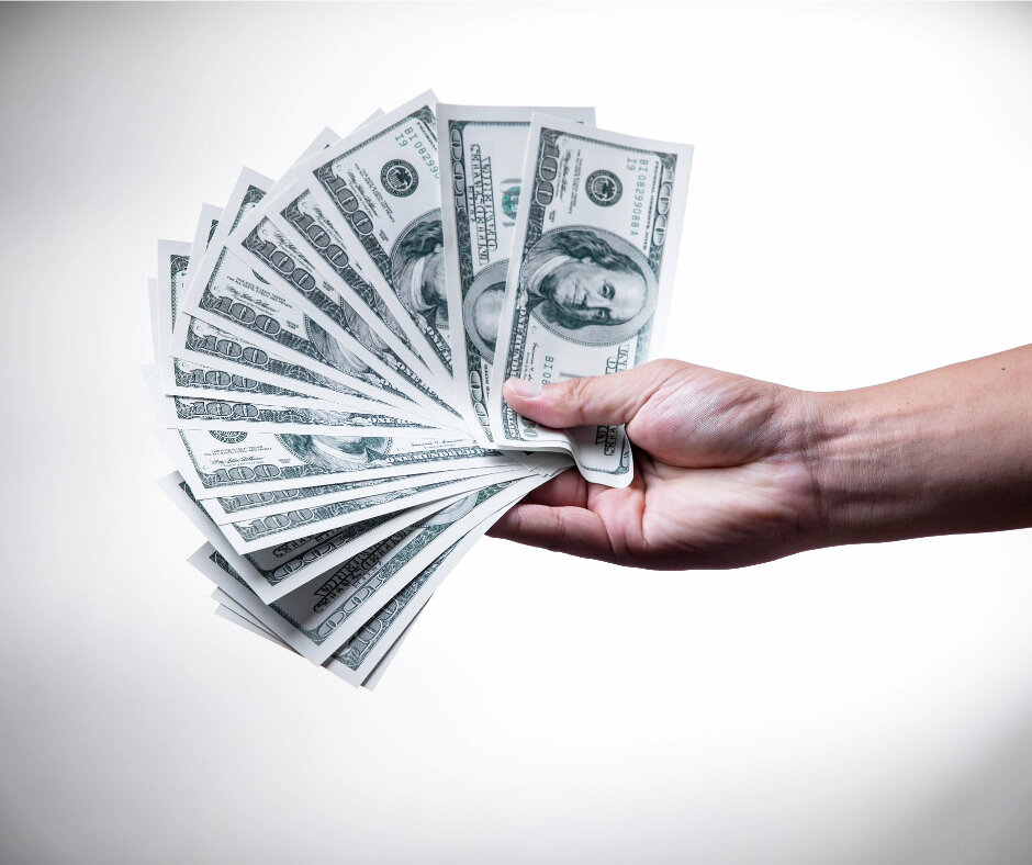 hand holding hundred dollar bills