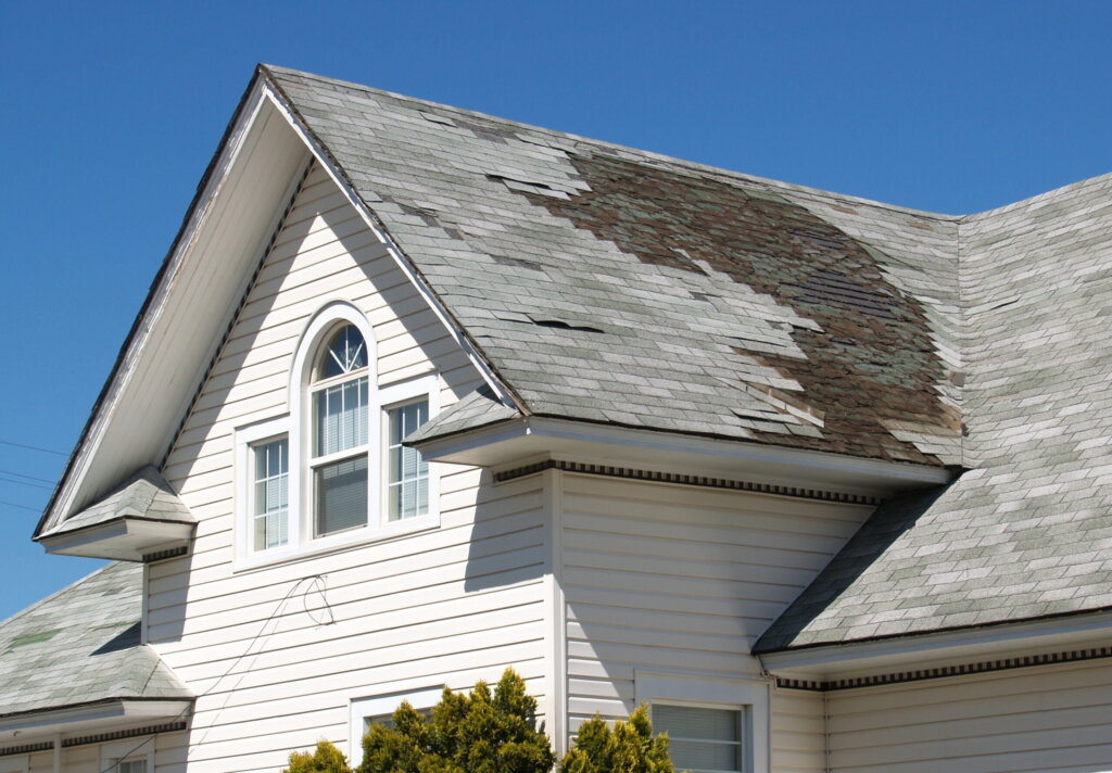 Oakland CA house with roof damage being evaluated before an as-is home sale