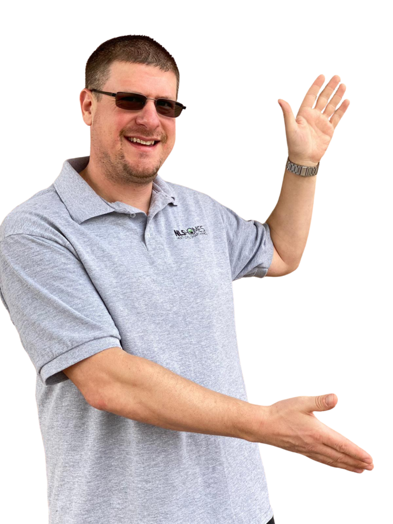 Smiling Man In Gray Polo Shirt Gesturing With Both Hands As If Presenting Or Pointing At Something