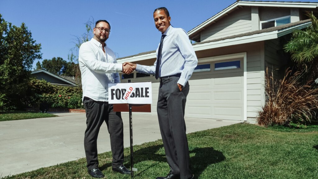 men shaking hands in front of the house