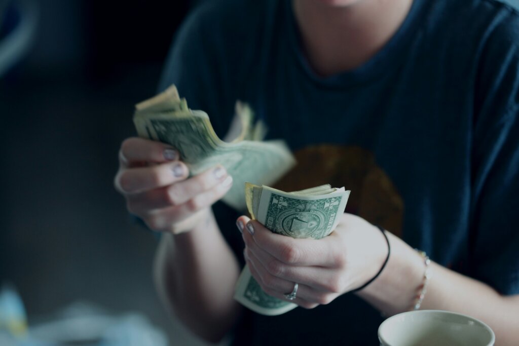 a person counting dollar banknotes