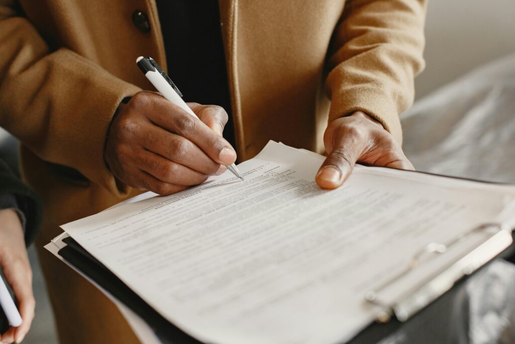 a person writing on white paper