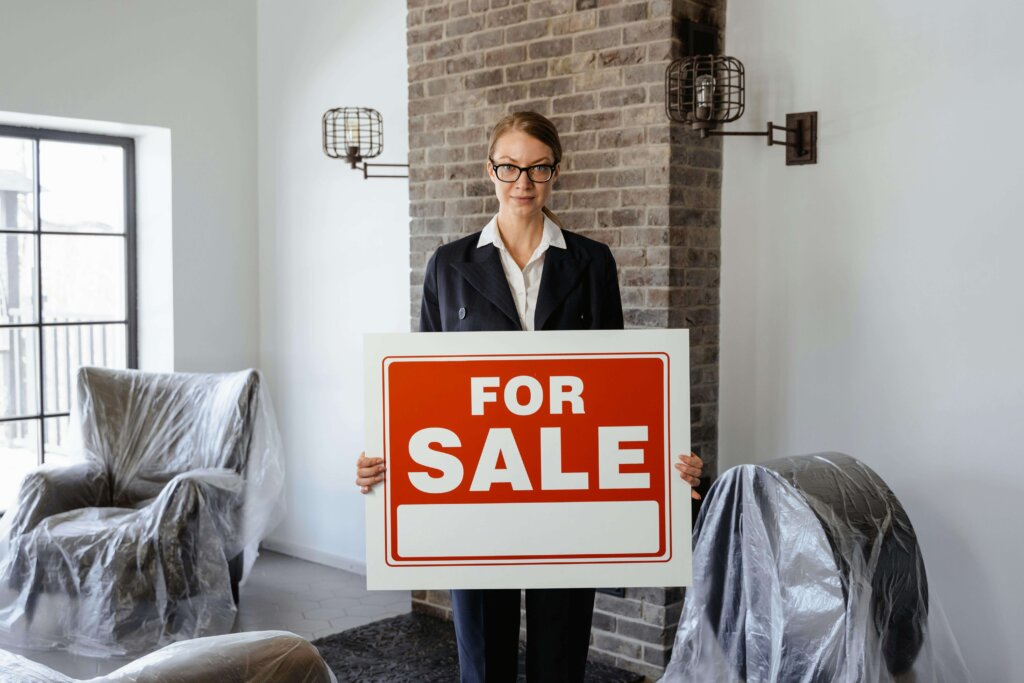 a real estate agent holding a sign