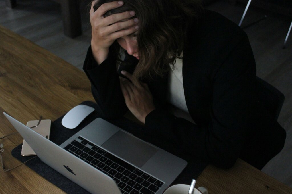 a stressed woman sitting in front of the laptop