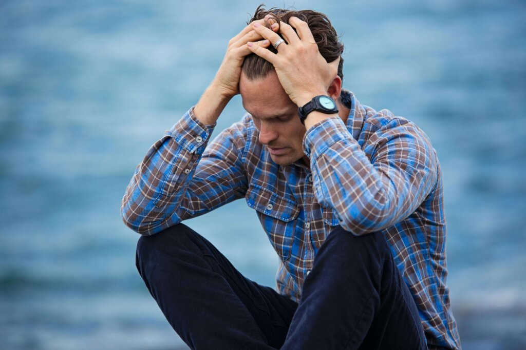 a man in blue shirt touching his hair