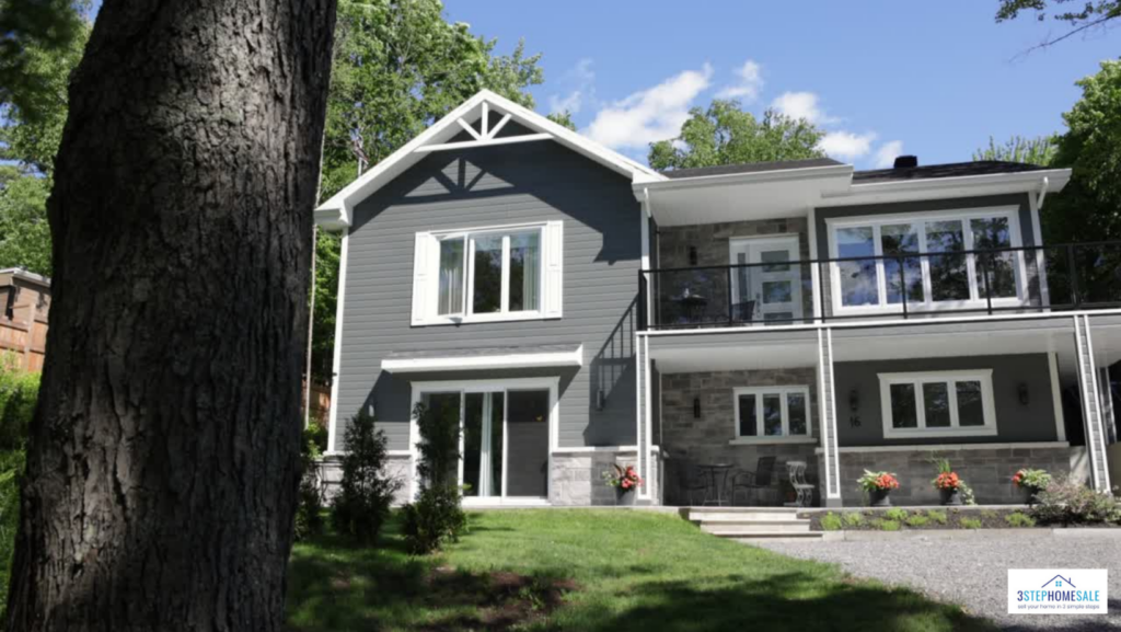 A spacious gray house with a large deck and yard
