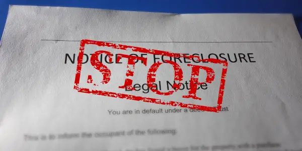 a foreclosure notice printed on paper with the word "stop" stamped on it