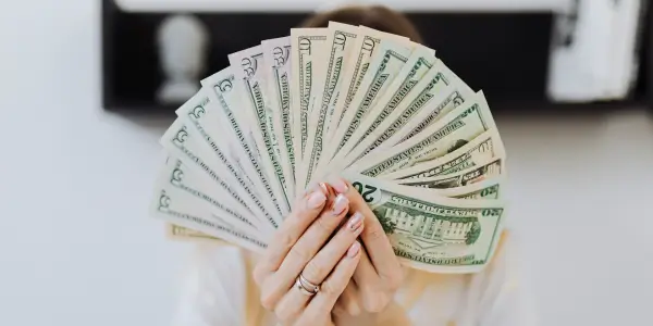 a lady holding paper bills spread like a fan