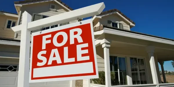 for sale sign in front of a house