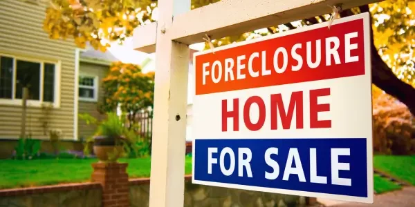 Foreclosure property available for sale, showing a house with a "For Sale" sign