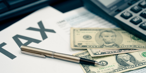 A close-up of a desk featuring a pen and tax papers, focusing on capital gains tax when selling inherited property
