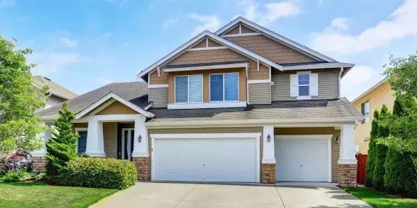 a 2-story house with white and brown paint