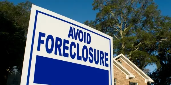 a blue signage with the words "avoid foreclosure" written to it