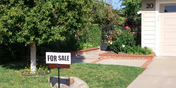 a for sale sign displayed on the lawn