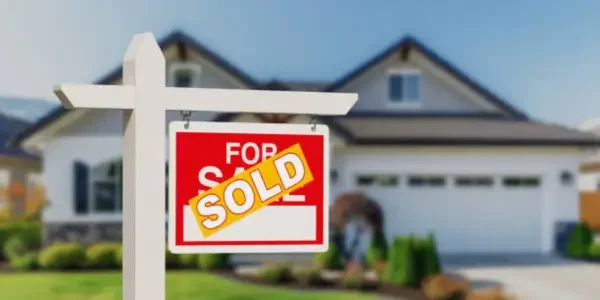 a for sale sign with a sold sign attached to it