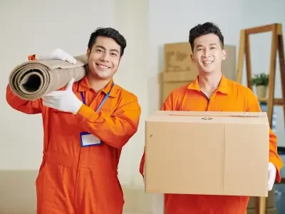 two hired movers carrying a carpet and a box