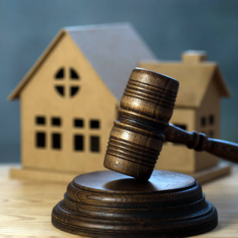 a gavel and a miniature house at the background